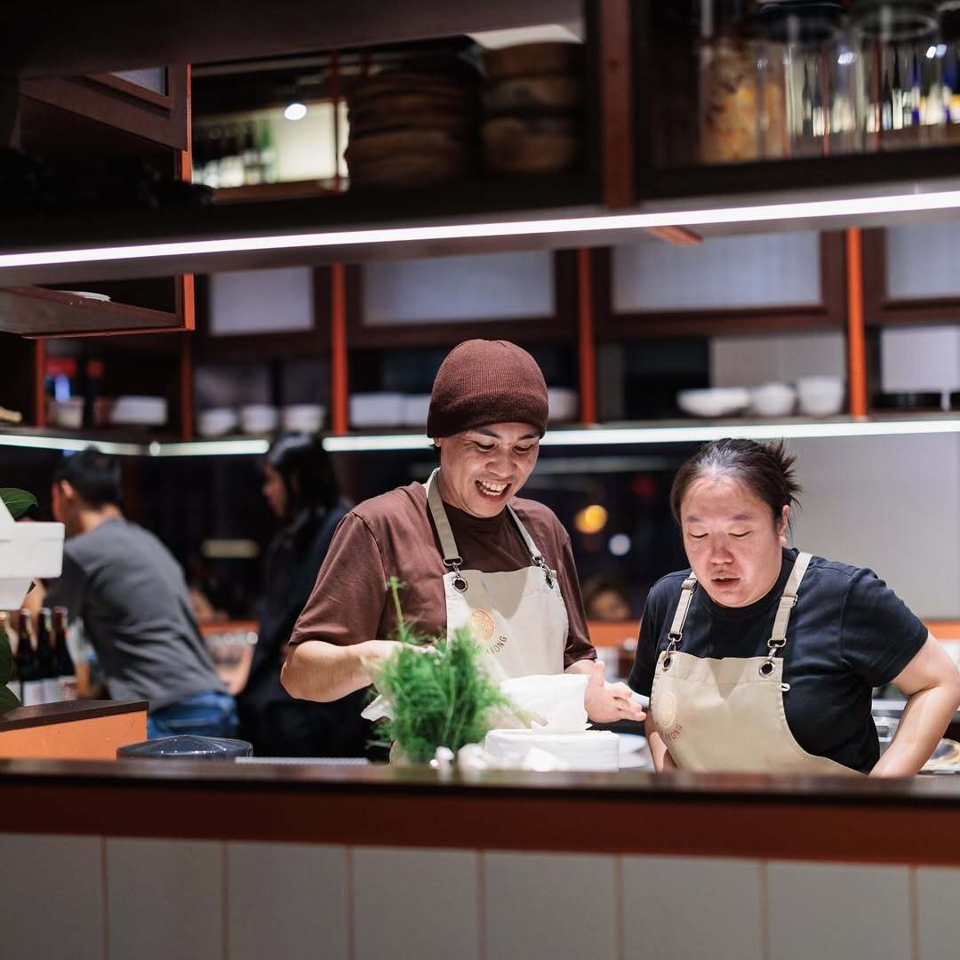 Two Bar Abong chefs plating dishes at the open kitchen pass